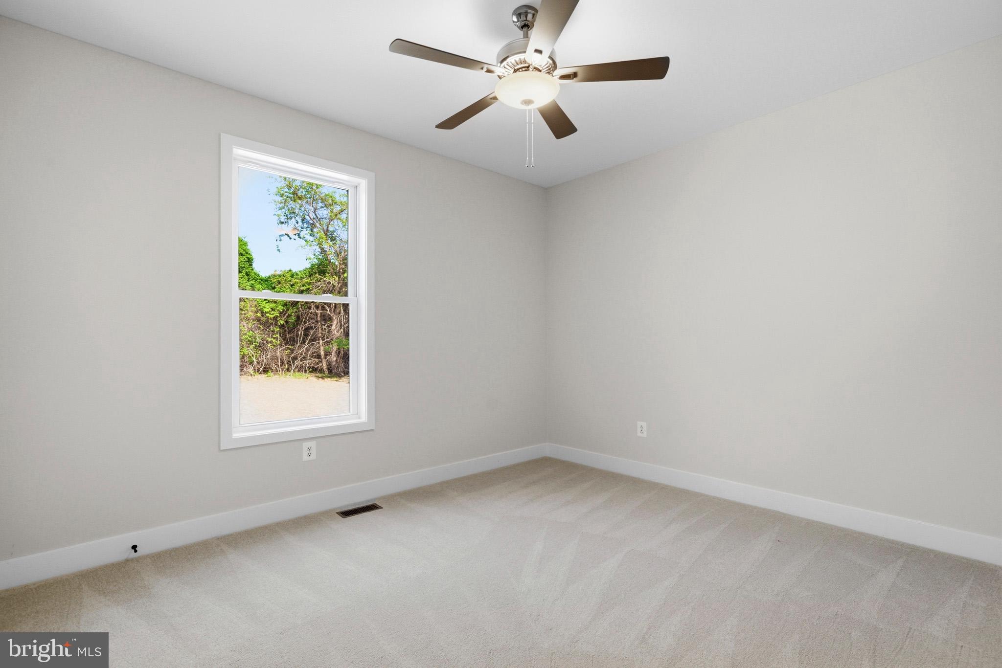 1362 Solomons Island Road Huntingtown, MD 20639 - Photo 22 of 37 an empty room with a window and a fan