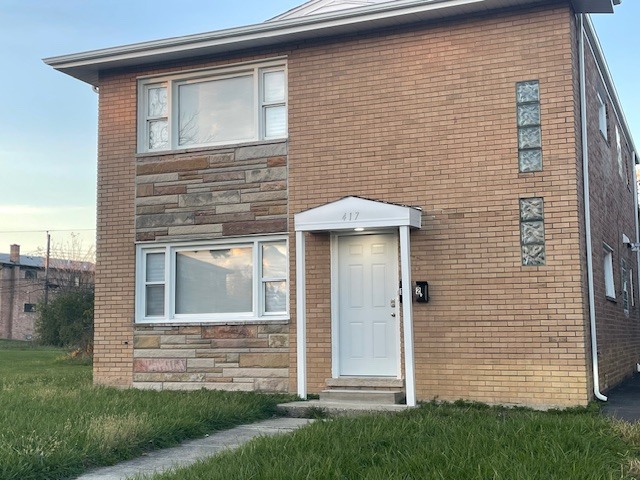 417 Hickory Street, Unit 1 Chicago Heights, IL 60411 - Photo 1 of 7 a front view of a house with a garden