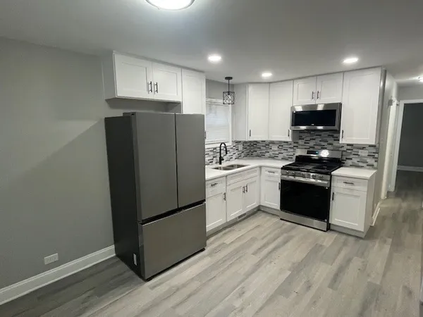 a kitchen with stainless steel appliances a refrigerator stove and wooden cabinets