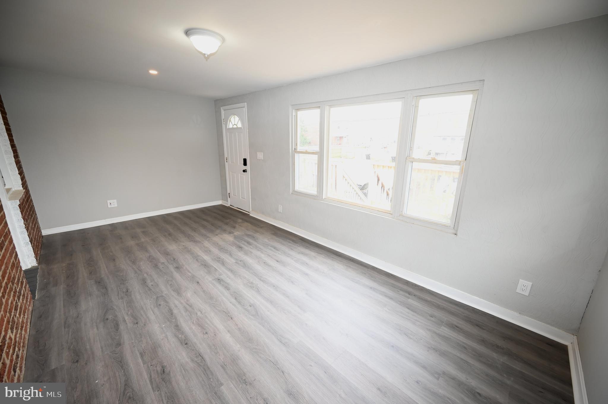 2952 Sollers Point Road, Unit B Dundalk, MD 21222 - Photo 32 of 37 an empty room with wooden floor and windows