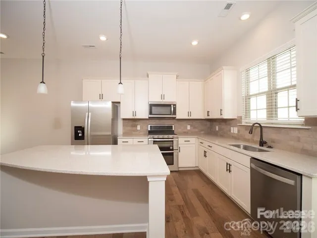 a kitchen with a sink a stove a refrigerator and a window