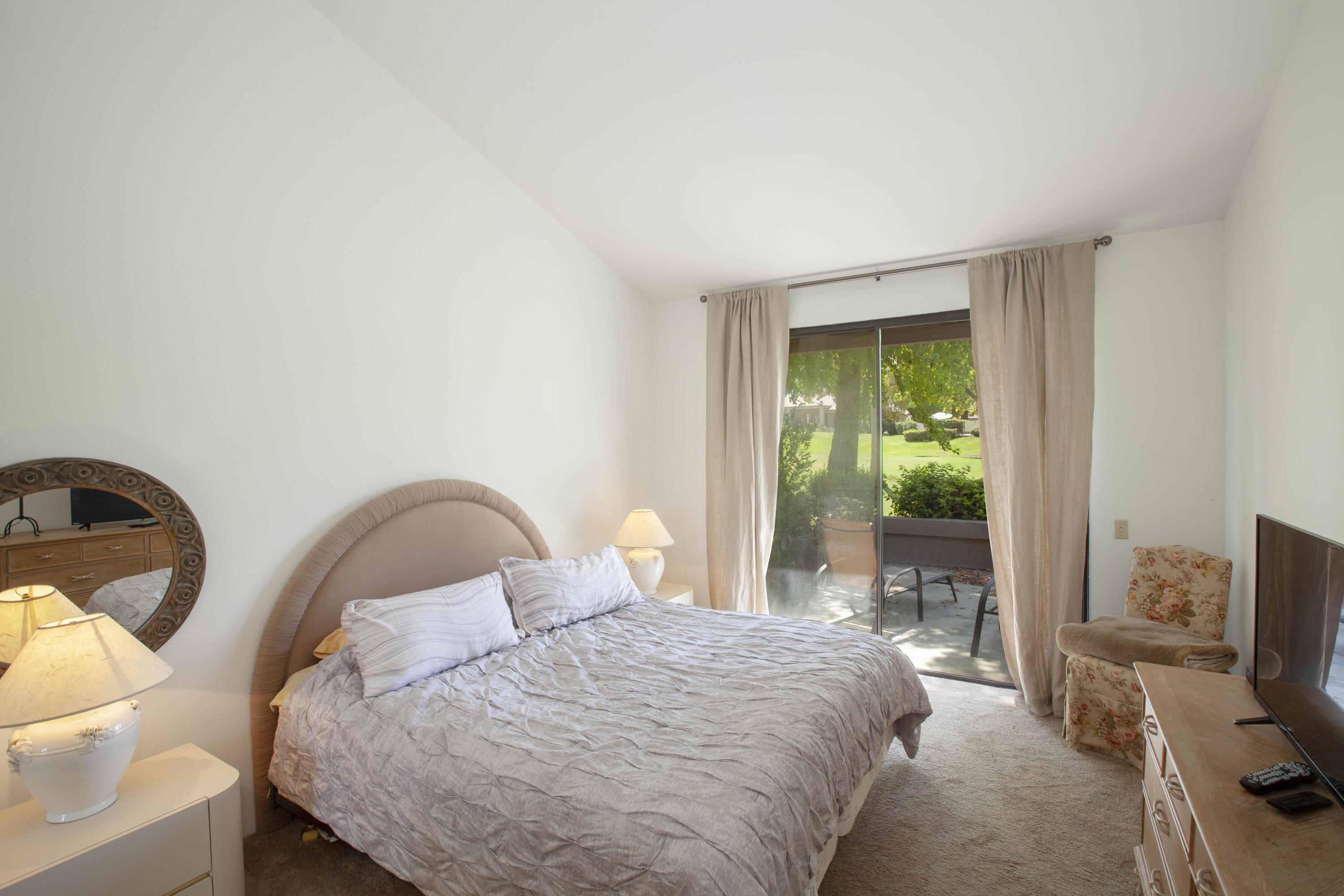 76131 Impatiens Circle Palm Desert, CA 92211 - Photo 16 of 27 a bedroom with a bed and a chair