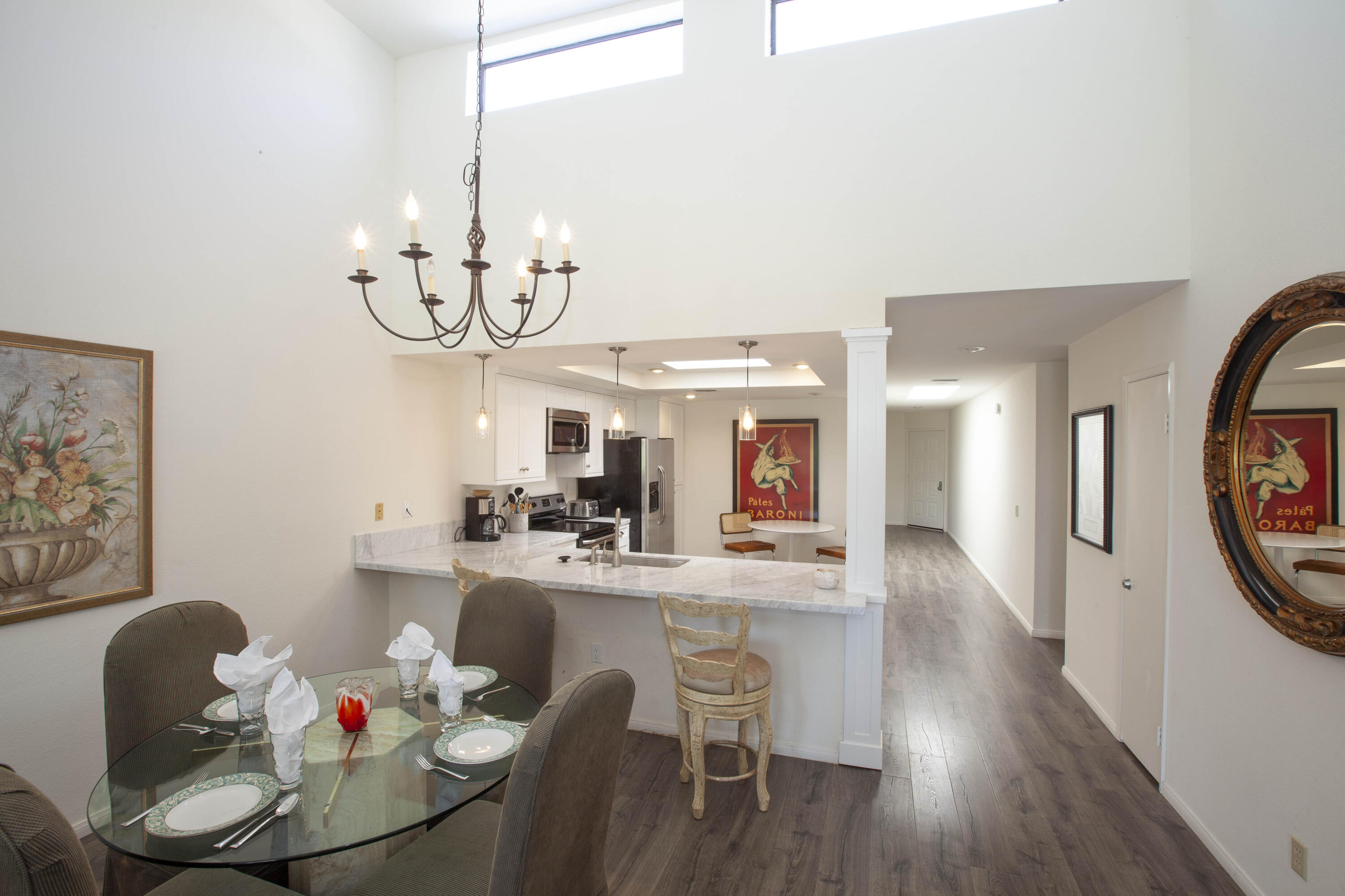 76131 Impatiens Circle Palm Desert, CA 92211 - Photo 8 of 27 a dining room with wooden floor a chandelier a wooden table and chairs