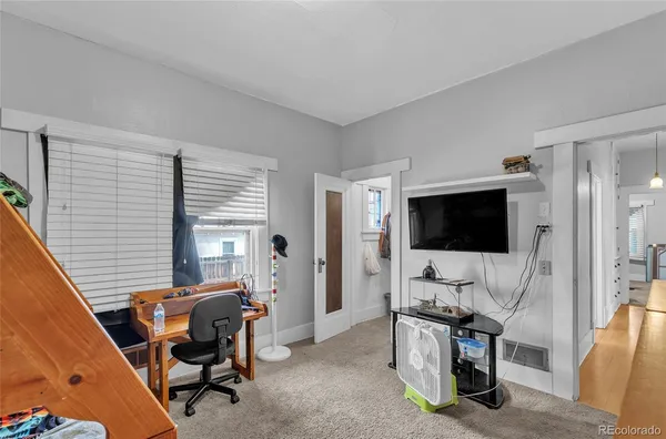 a view of a livingroom with workspace and a window