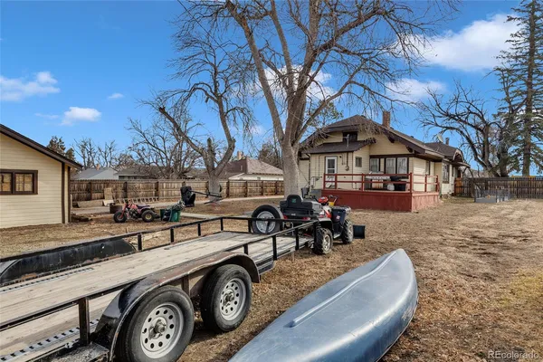 a front view of a house with large trees