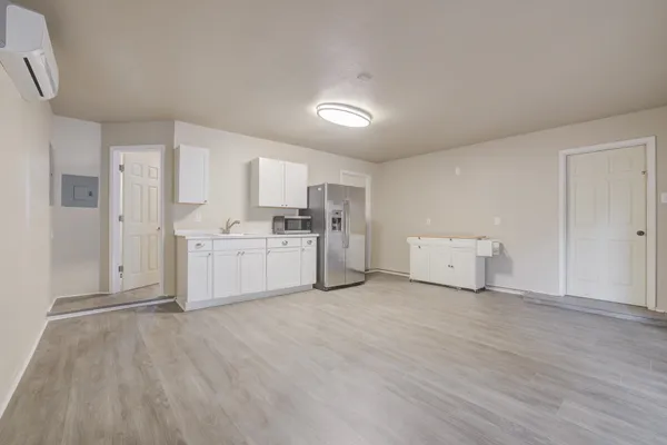 a view of a kitchen with white cabinets and wooden floor