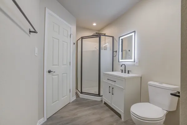 a bathroom with a toilet a sink a mirror a vanity and window