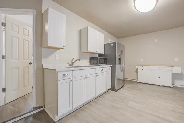 a kitchen with white cabinets and white appliances