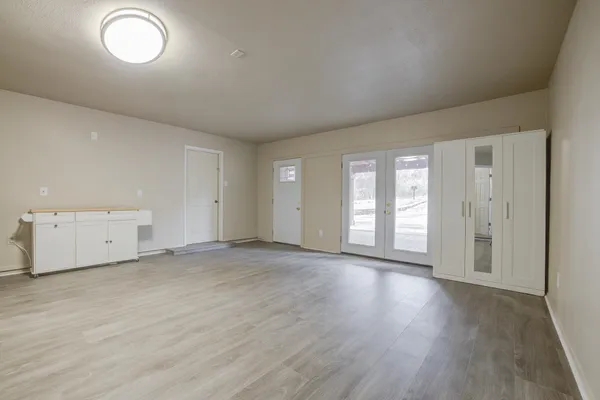 an empty room with wooden floor and window