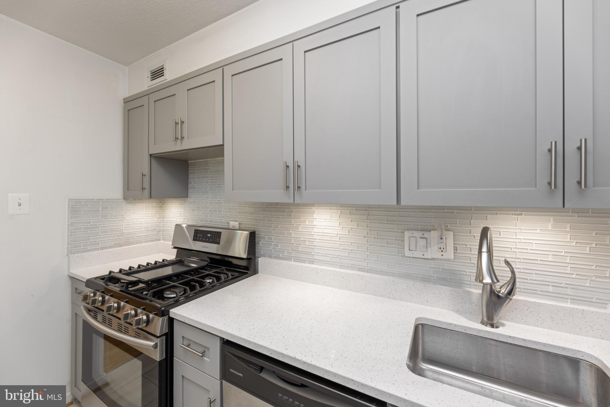 490 M Street Southwest, Unit W101 Washington, DC 20024 - Photo 9 of 26 a kitchen with white cabinets and appliances