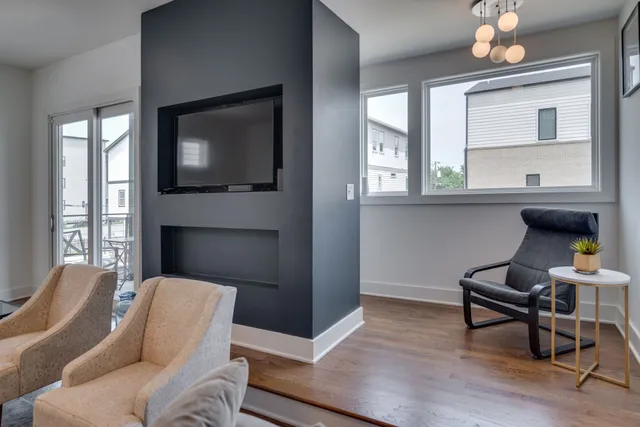a living room with furniture a fireplace and a flat screen tv