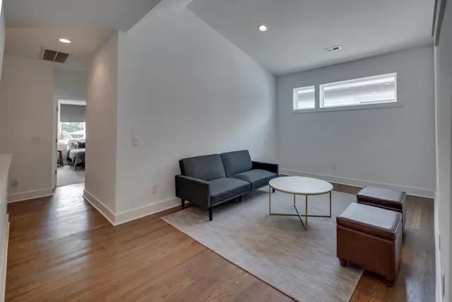 a living room with furniture and a wooden floor