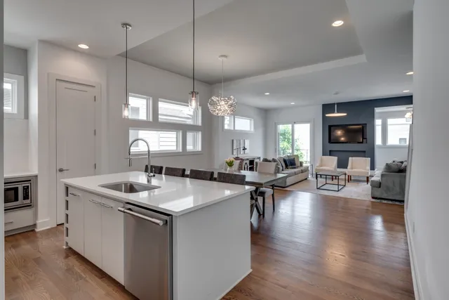 a kitchen with sink stove and living room