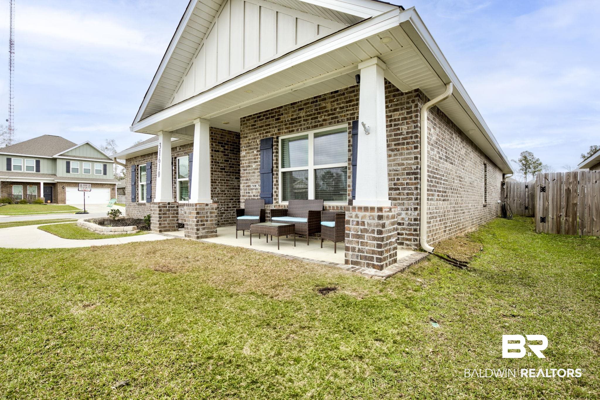 31610 Memphis Loop Daphne, AL 36527 - Photo 43 of 67 View of front of property with a front lawn, fence, board and batten siding, an outdoor hangout area, and brick siding