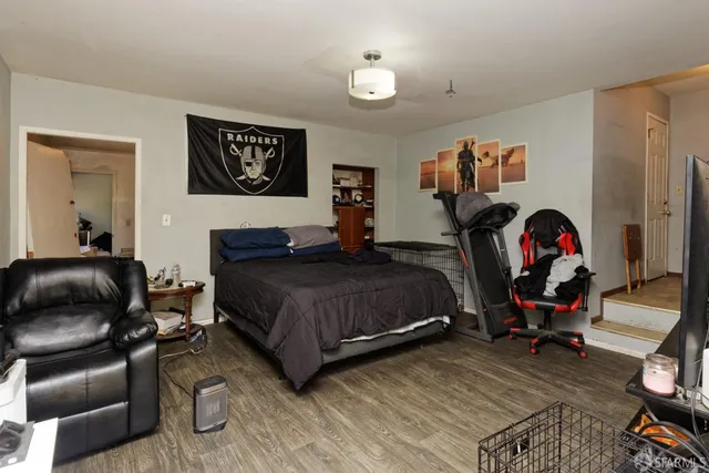 a bedroom with a bed and wooden floor