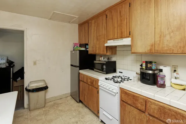 a kitchen with stainless steel appliances a stove a sink a refrigerator and cabinets