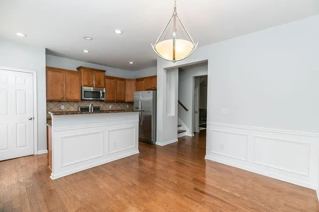 a kitchen with stainless steel appliances granite countertop a refrigerator and a stove top oven