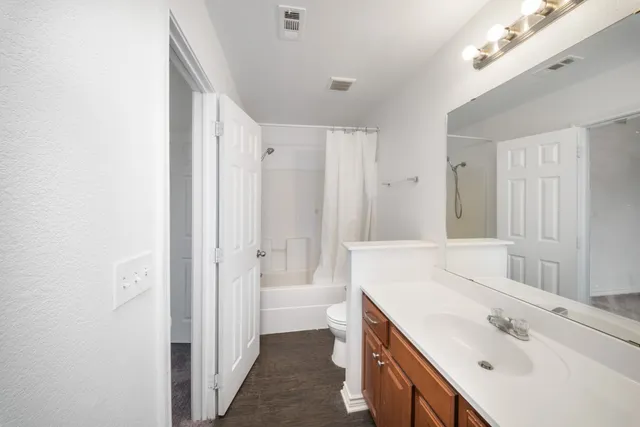 a spacious bathroom with a double vanity sink a mirror and a bathtub