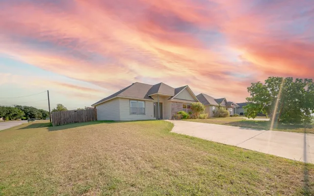 a view of an house with backyard and road