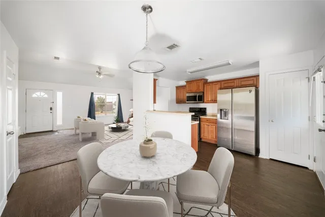 a dining room with furniture a chandelier and wooden floor