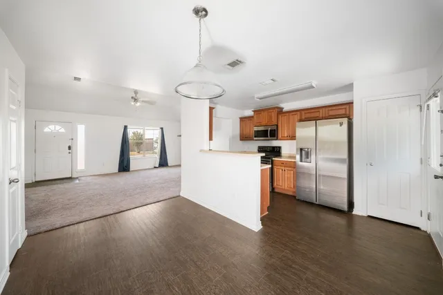 a view of a kitchen with a sink and dishwasher a refrigerator with wooden floor