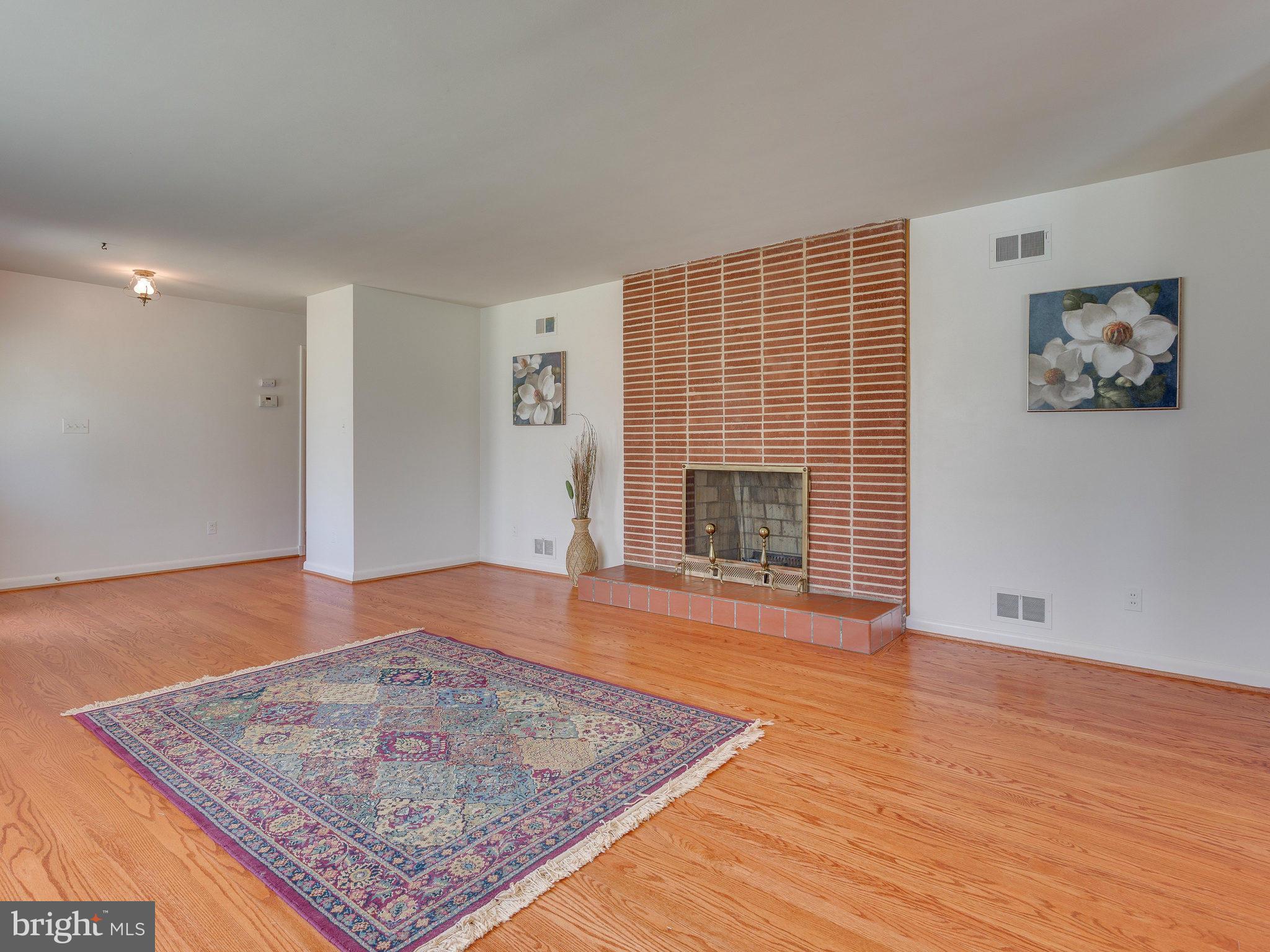 6714 Greenleaf Street Springfield, VA 22150 - Photo 4 of 30 an empty room with wooden floor and fireplace