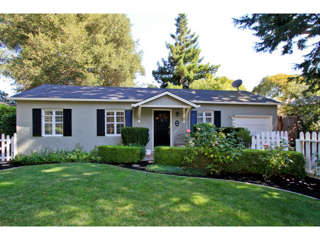 a view of a house with a yard and potted plants