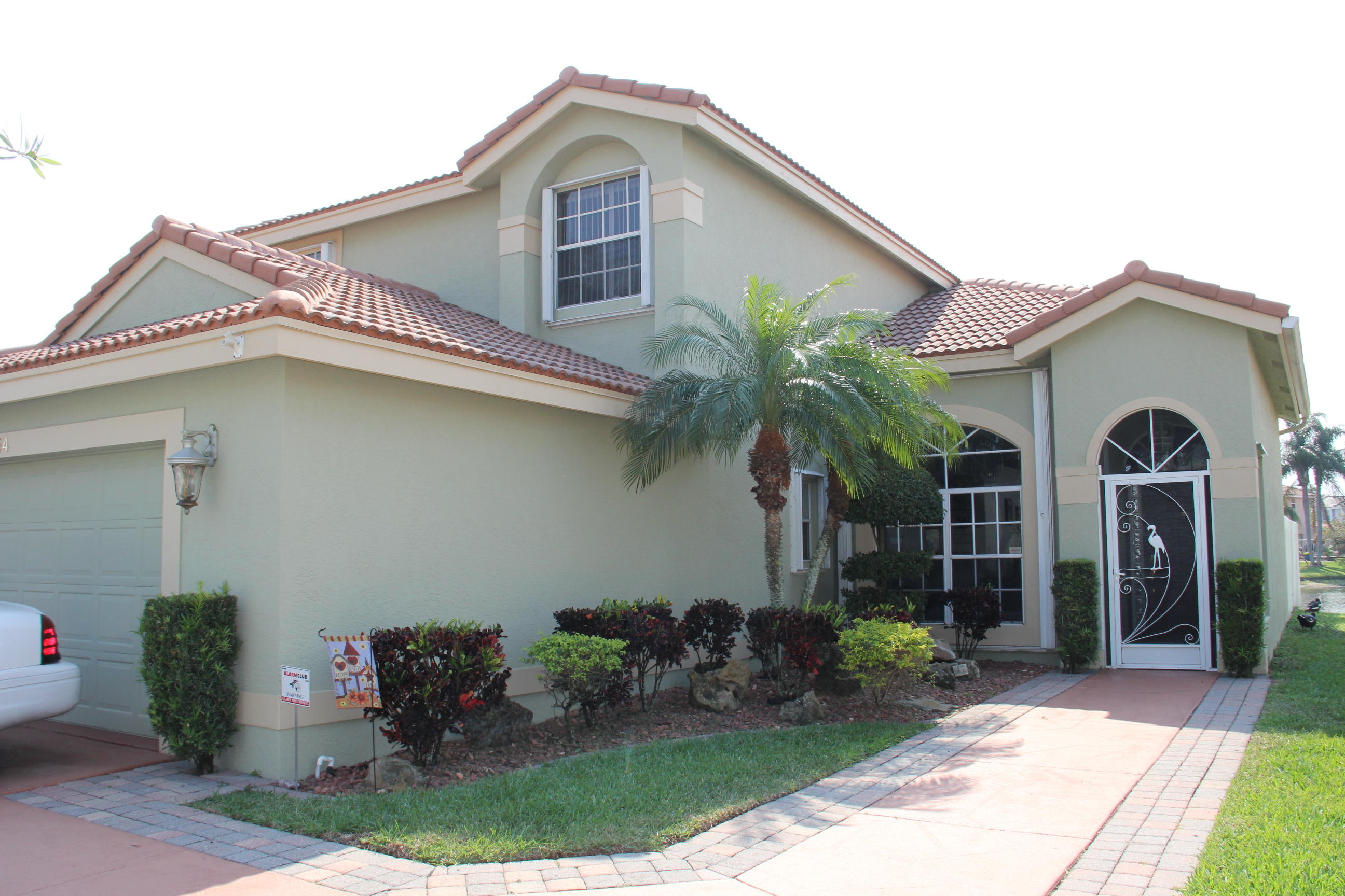 7354 Michigan Isle Road Lake Worth, FL 33467 - Photo 1 of 21 a front view of a house with garden