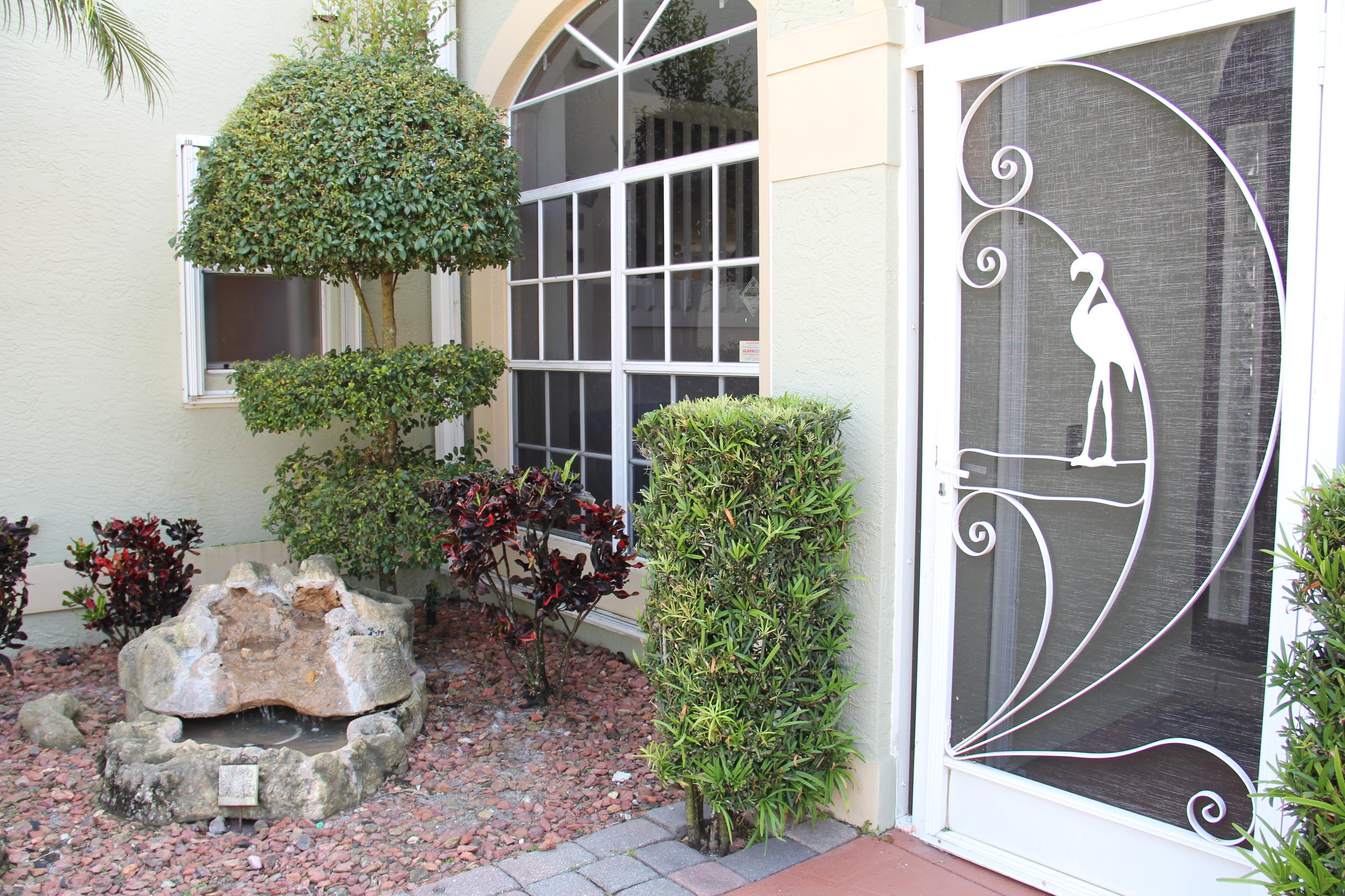 7354 Michigan Isle Road Lake Worth, FL 33467 - Photo 2 of 21 a front view of a house with garden