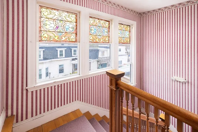 a view of a balcony with a couple of cars parked in front of house
