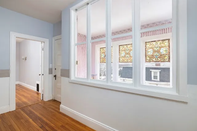 an entryway with wooden floor and windows