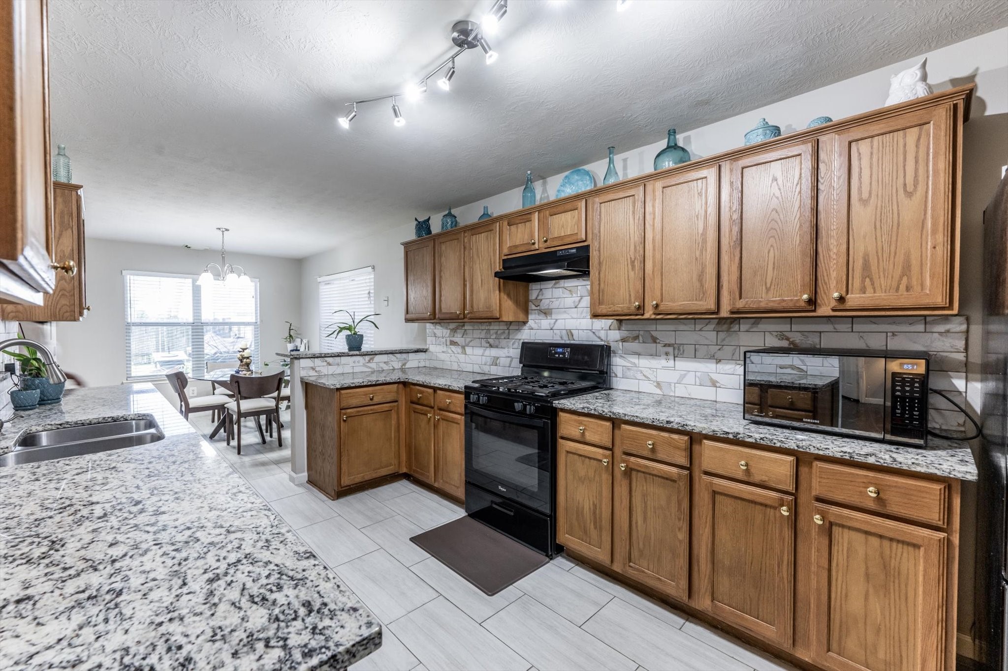 13507 Beech Ridge Lane Houston, TX 77083 - Photo 15 of 49 a kitchen with stainless steel appliances granite countertop wooden cabinets a stove top oven a sink and dishwasher