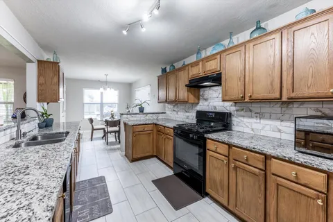 a kitchen with stainless steel appliances granite countertop a stove sink and cabinets