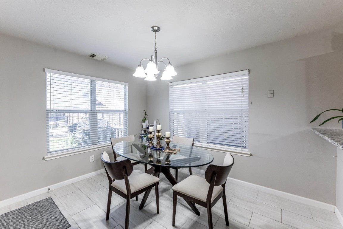 13507 Beech Ridge Lane Houston, TX 77083 - Photo 17 of 49 a dining room with furniture a chandelier and window