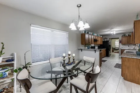 a dining room filled chandelier and kitchen view