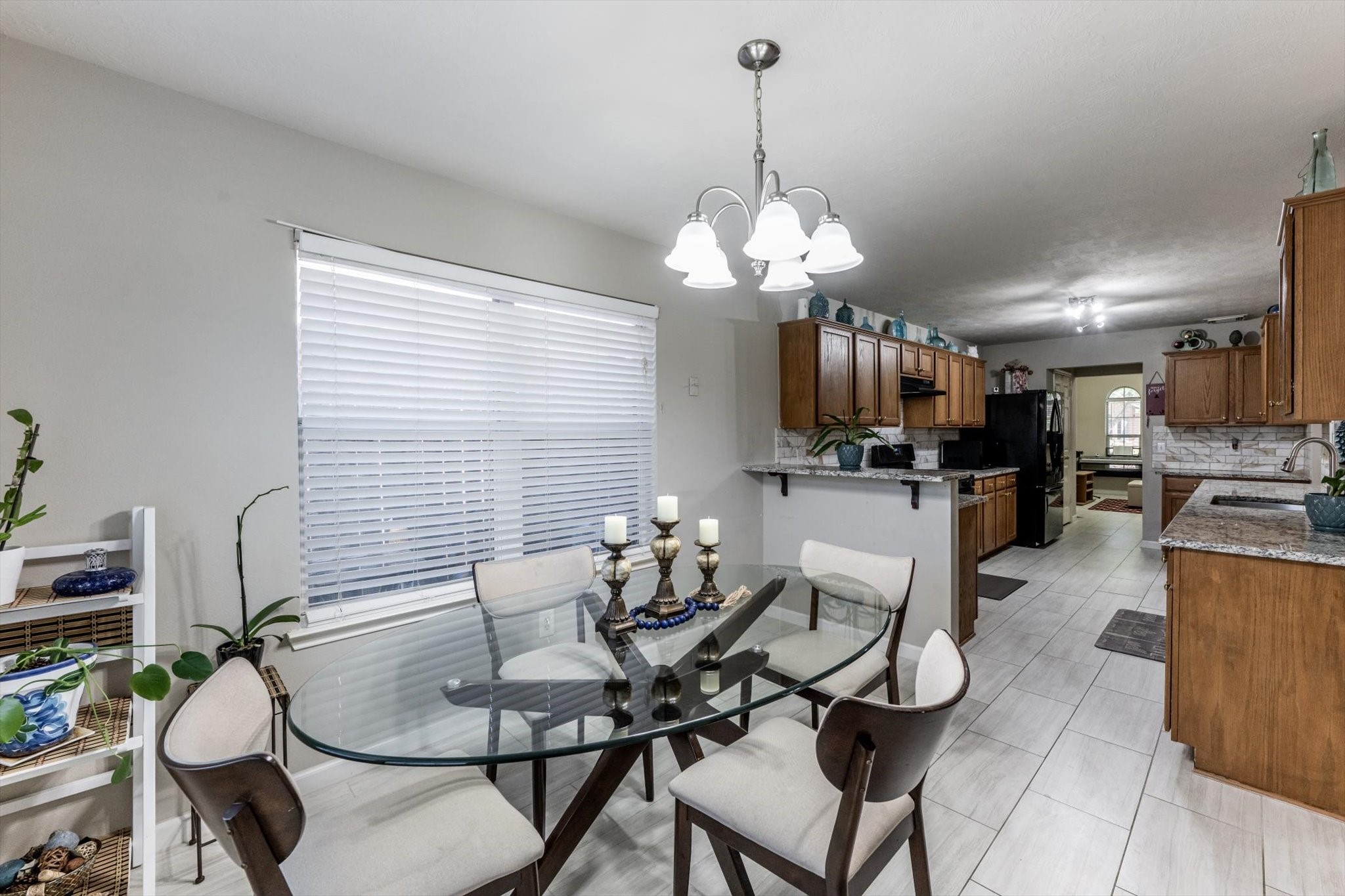 13507 Beech Ridge Lane Houston, TX 77083 - Photo 19 of 49 a dining room filled chandelier and kitchen view