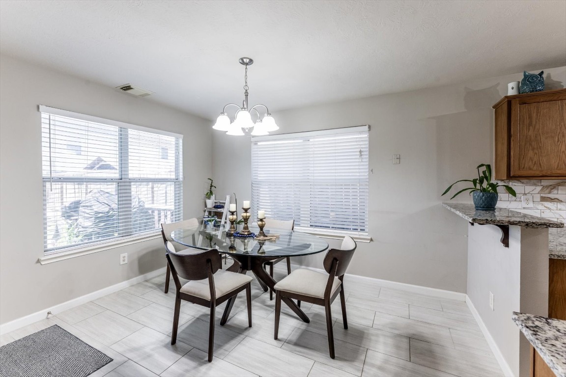 13507 Beech Ridge Lane Houston, TX 77083 - Photo 20 of 49 a view of a dining room with furniture and a chandelier