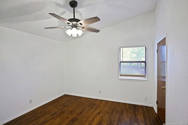 a view of wooden floor and chandelier fan in a room