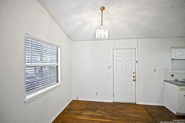 a view of empty room with window and wooden floor