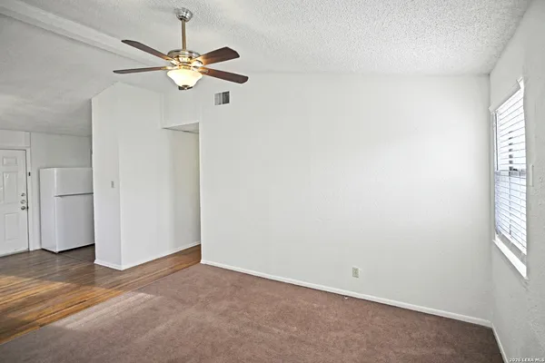 an empty room with a window and a fan