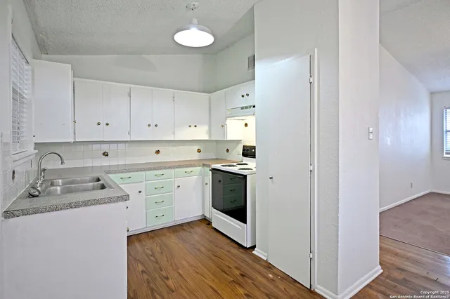 a kitchen with cabinets stainless steel appliances and sink