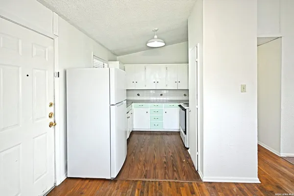 a kitchen with a refrigerator a sink and wooden floor