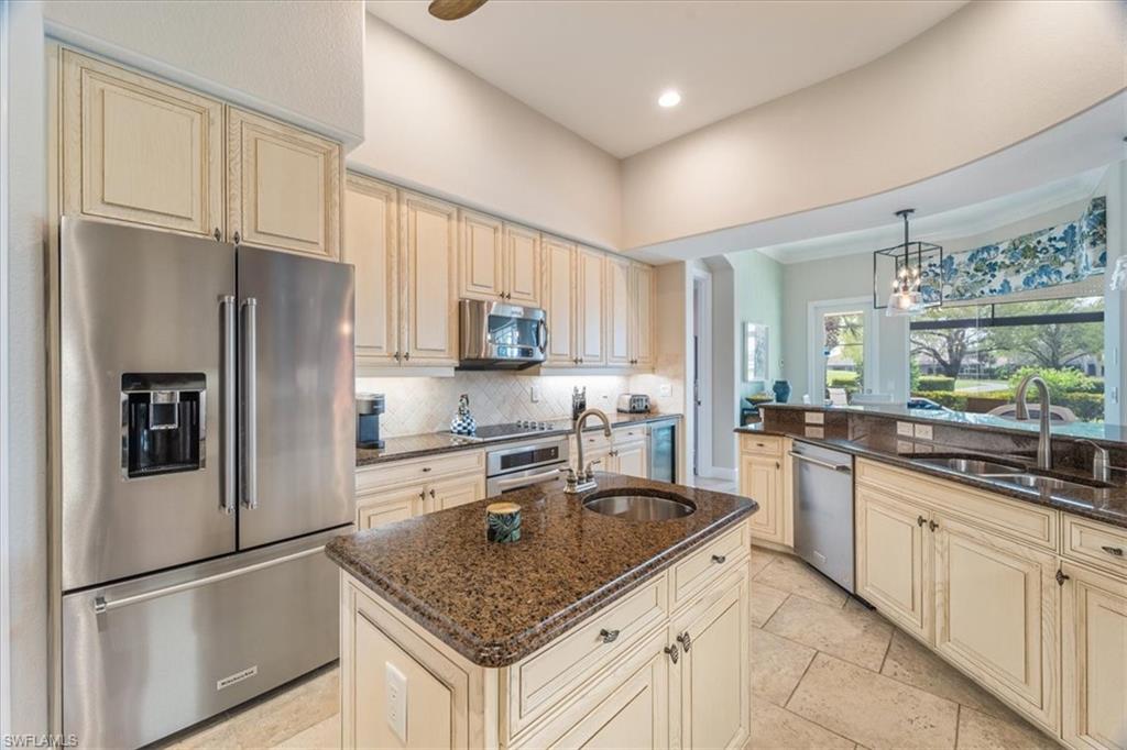12130 Wicklow Lane Naples, FL 34120 - Photo 13 of 45 a kitchen with stainless steel appliances granite countertop a refrigerator a sink dishwasher a stove and white countertops with wooden floor