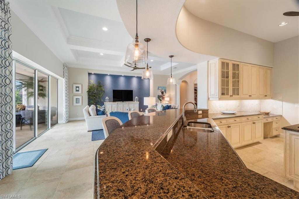 12130 Wicklow Lane Naples, FL 34120 - Photo 15 of 45 a large kitchen with sink stove and a dining table with chairs