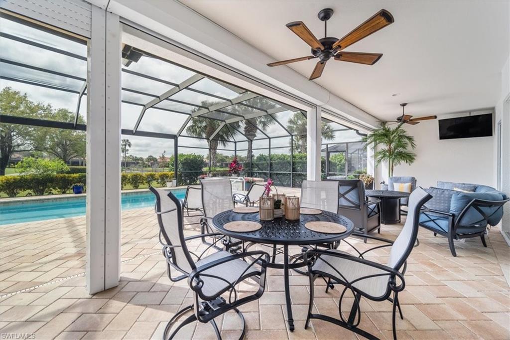 12130 Wicklow Lane Naples, FL 34120 - Photo 33 of 45 a dining room with furniture a chandelier and a large window