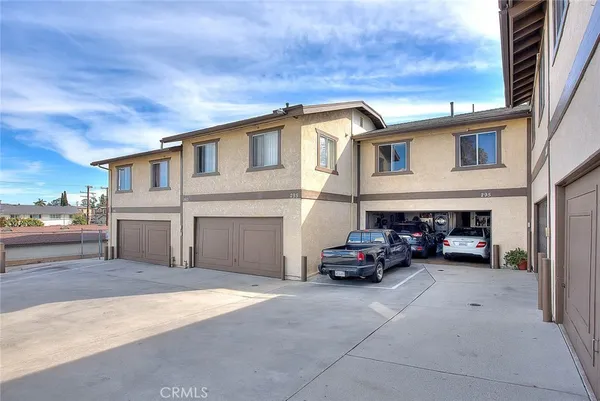 a view of a patio with couches and table and chairs under an umbrella