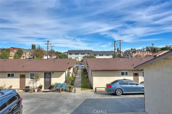 a view of a house with a small yard plants and a large tree