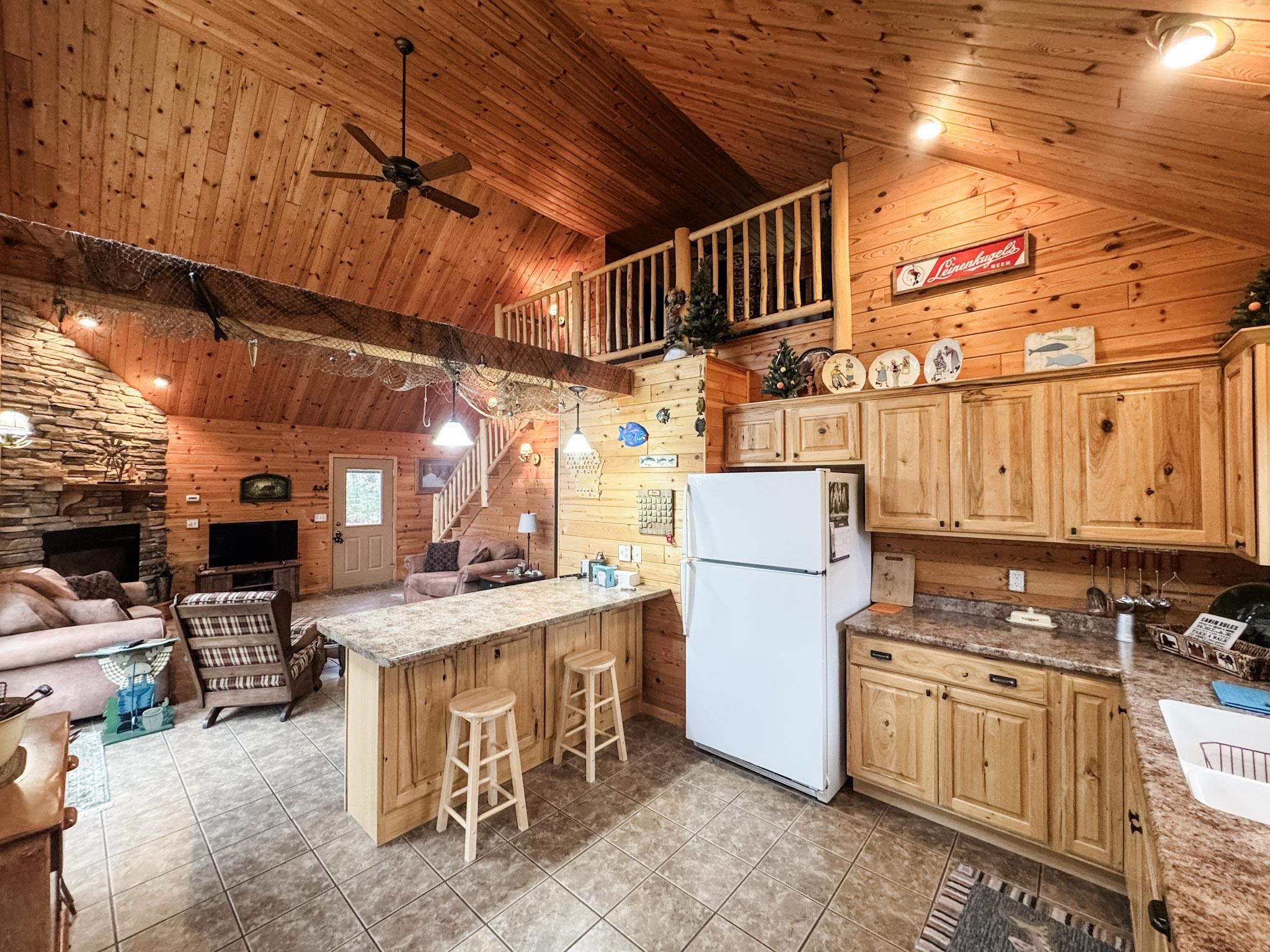 11466 Westerlund Loop Solon Springs, WI 54873 - Photo 16 of 55 Kitchen featuring wooden walls, wooden ceiling, freestanding refrigerator, ceiling fan, and a breakfast bar area