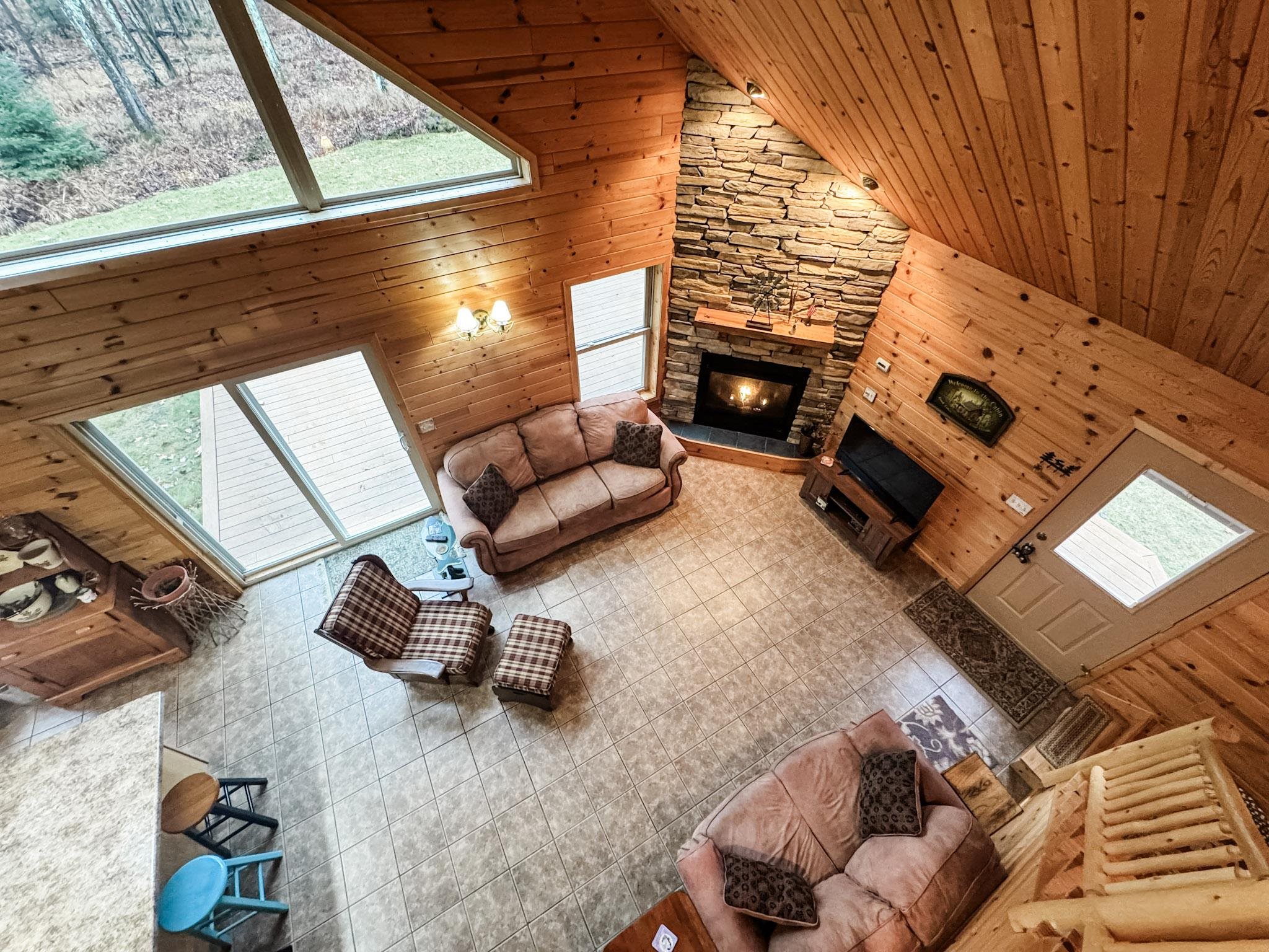 11466 Westerlund Loop Solon Springs, WI 54873 - Photo 20 of 55 Living area with wood walls, high vaulted ceiling, a fireplace, and wooden ceiling