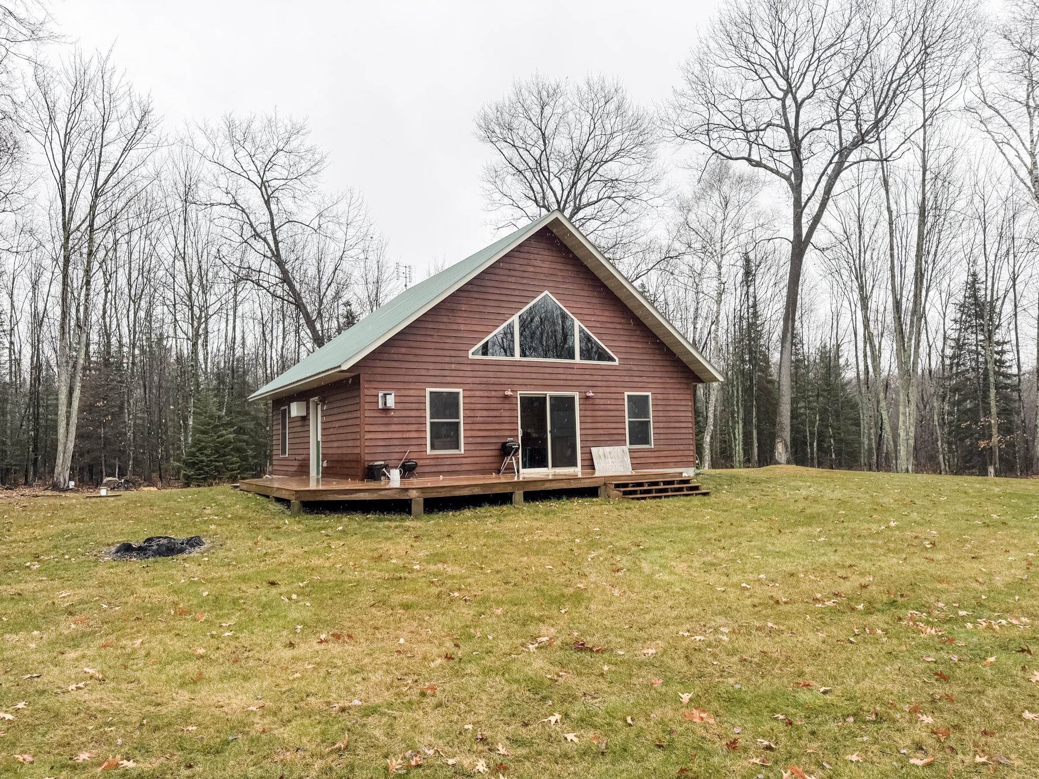 11466 Westerlund Loop Solon Springs, WI 54873 - Photo 2 of 55 Rear view of house featuring a lawn, a deck, and a view of trees